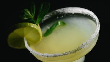 Close-up shot of a margarita cocktail in dim lighting.