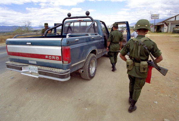 Soldiers from the Mexican army search cars in the