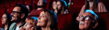 People enjoying movie in theater.
