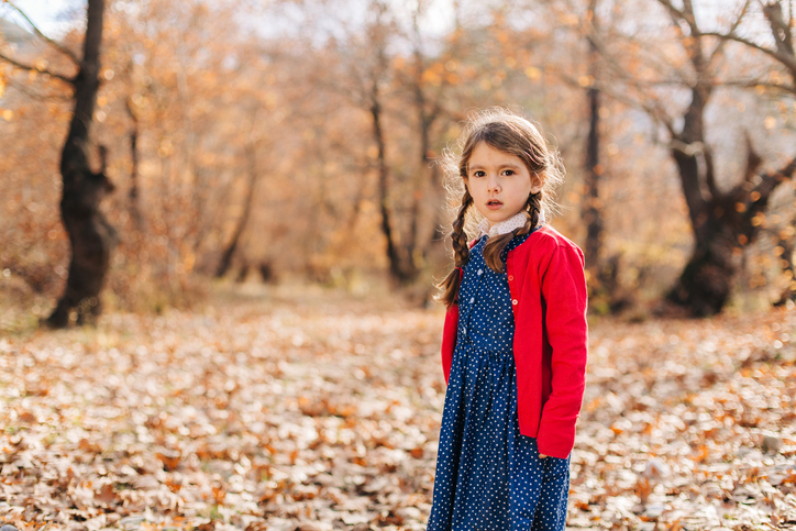 Little girl in autumn forest