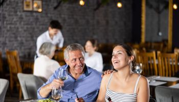 Senior man spending time with young girl in restaurant