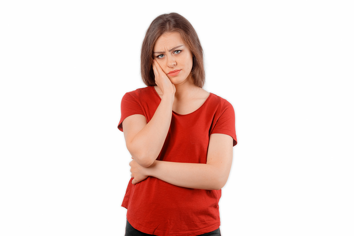 Young bored woman looking at camera, feel fatigue, need some relaxation. Winsome female model in red t shirt posing over white studio background