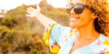 Portrait of happy cheerful woman in outdoor leisure activity alone smiling and enjoying freedom in sunset light time. Travel people. Healthy lifestyle and nature. Adult female happy and free person
