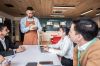 Coworkers being served through waiter at office coffee shop