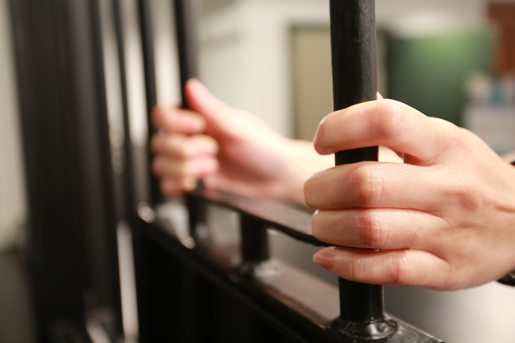 Female young Hand holding the window of jail