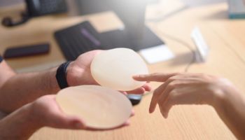 Female hand picks silicone implants for breast augmentation