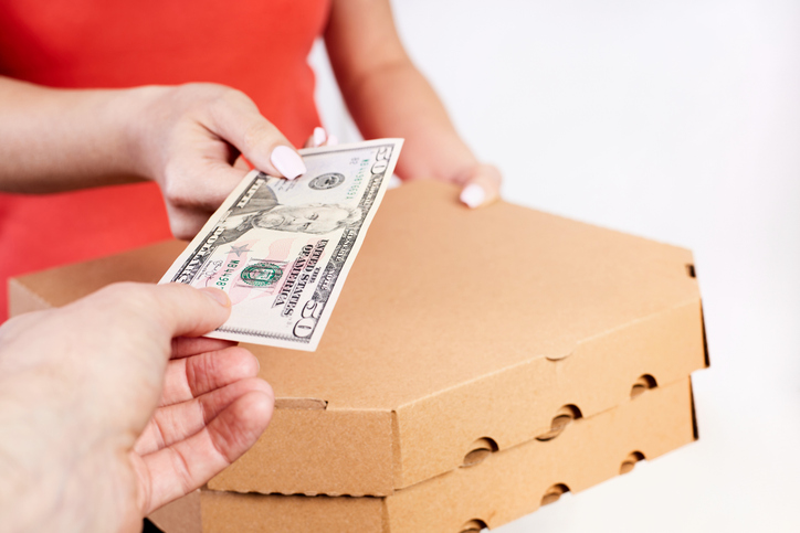 The customer pays the pizza to the delivery man in cash