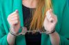 Arrested blonde woman in police handcuffs